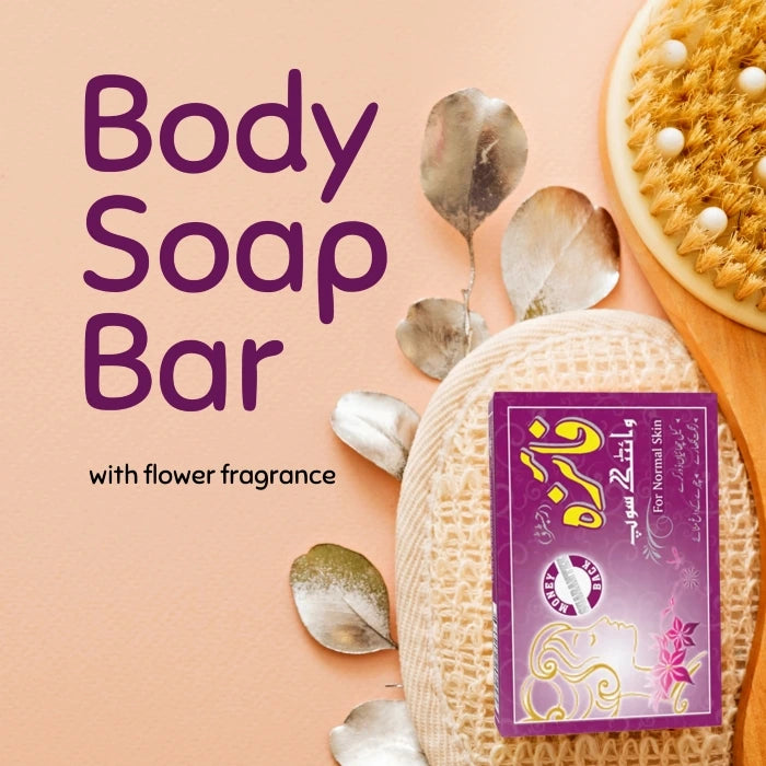 Faiza Whitening Soap for normal skin displayed in a bath setting with dried leaves, a loofah, and a body scrub brush.